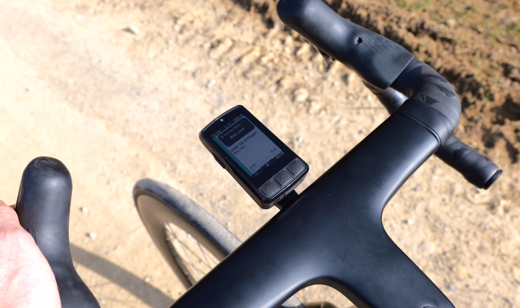 Wahoo ELEMNT BOLT V3 am Rennradlenker mit Musiksteuerung auf dem Display während der Fahrt.