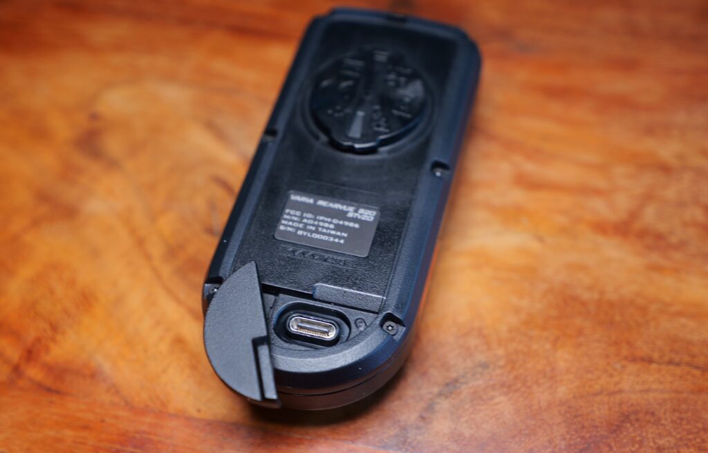 Rückseite des Garmin RearVue 820 mit geöffnetem Ladeport und sichtbarem USB-C-Anschluss.