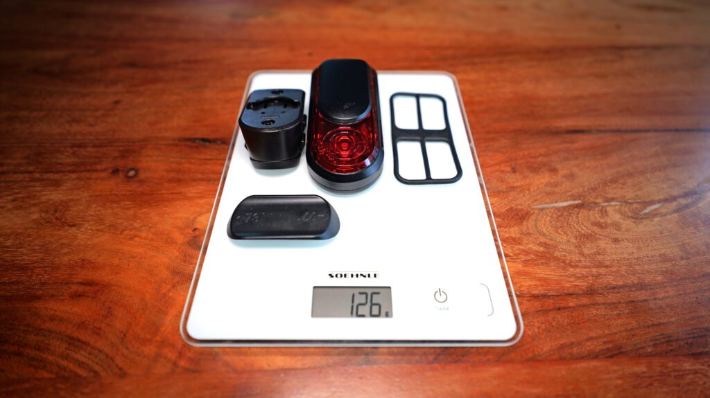 Garmin RearVue 820 mit Halterung, Gummieinsatz und Abdeckung auf digitaler Waage, Gesamtgewicht 126 Gramm.