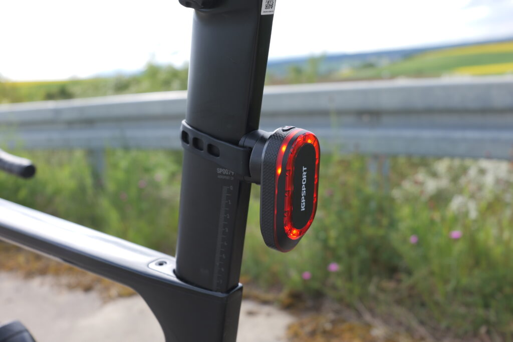 iGPSport SR Mini Rücklicht an der Sattelstütze eines Canyon Aeroad in Nahaufnahme, montiert mit Gummiband-Halterung.
