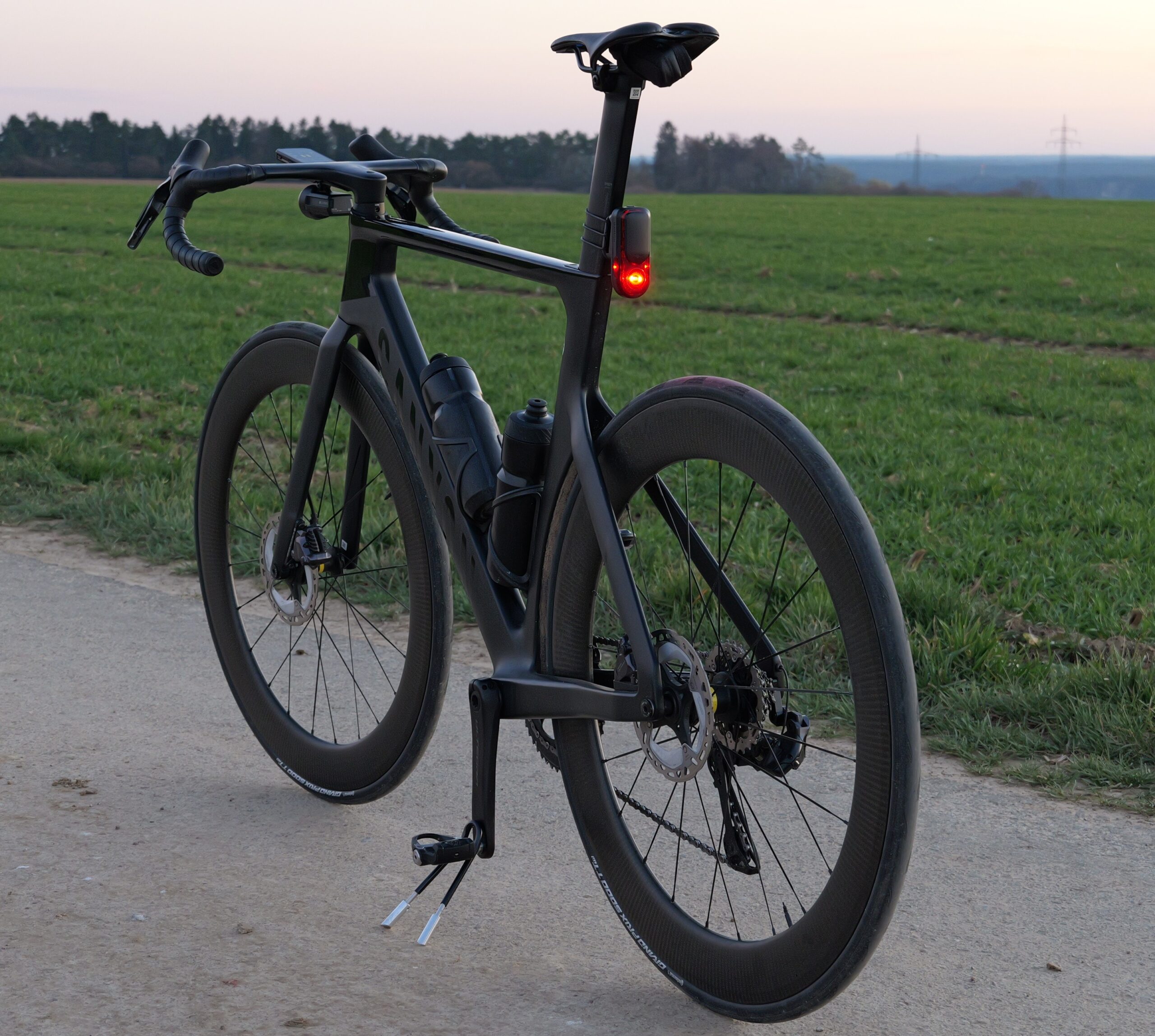 Rennrad Sichtbarkeit erhöhen mit hellem Rücklicht bei Dunkelheit auf nasser Straße