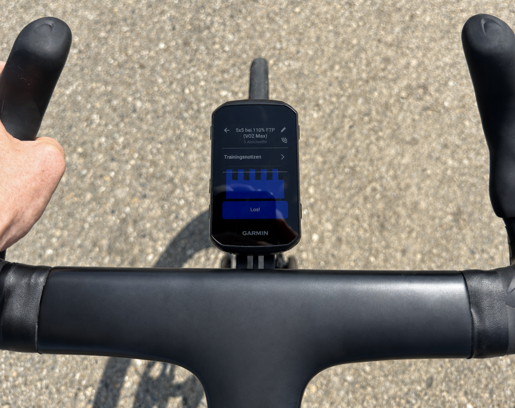 Blick aus der Fahrerperspektive auf einen schwarzen Fahrradlenker mit Garmin Edge 850. Auf dem Display ist ein VO₂max-Intervalltraining mit fünf Abschnitten bei 110 Prozent FTP geöffnet.