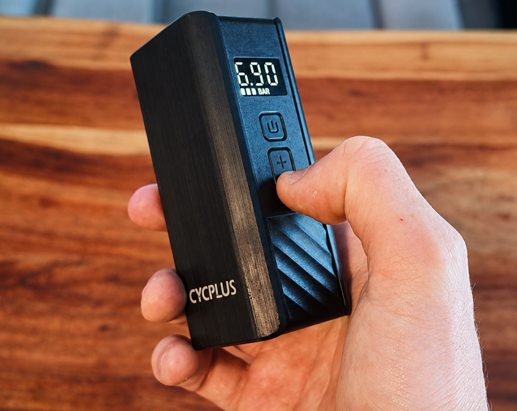 CYCPLUS A3 Mini elektrische Fahrradpumpe in der Hand mit digitaler Druckanzeige von 6,90 Bar.