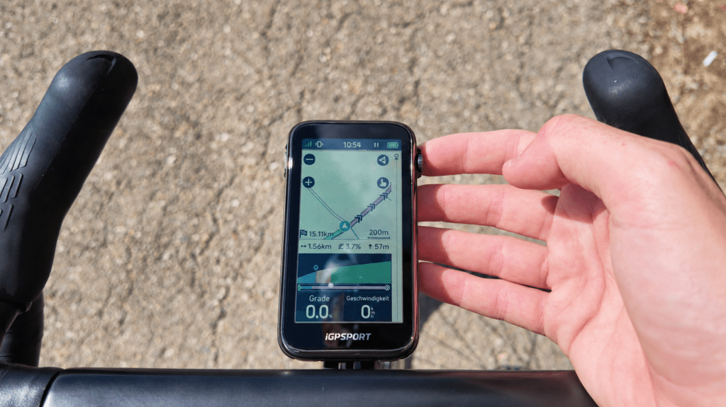 iGPSPORT BiNavi Ultra: Display und Karte iGPSPORT BiNavi Ultra mit farbiger Kartenansicht und Hand am Drehrad